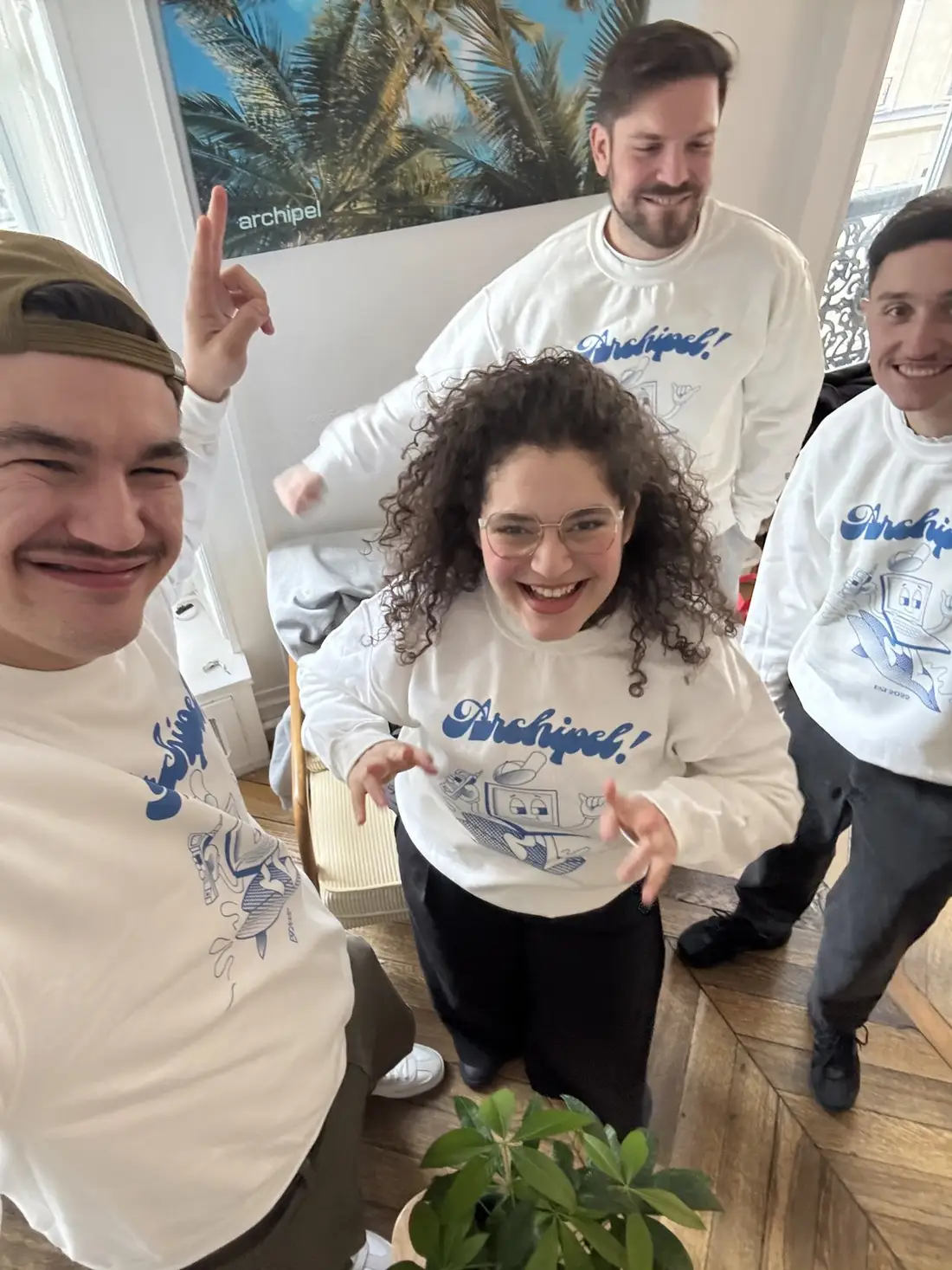 The Archipel team in agency sweatshirts, one finger raised for first place